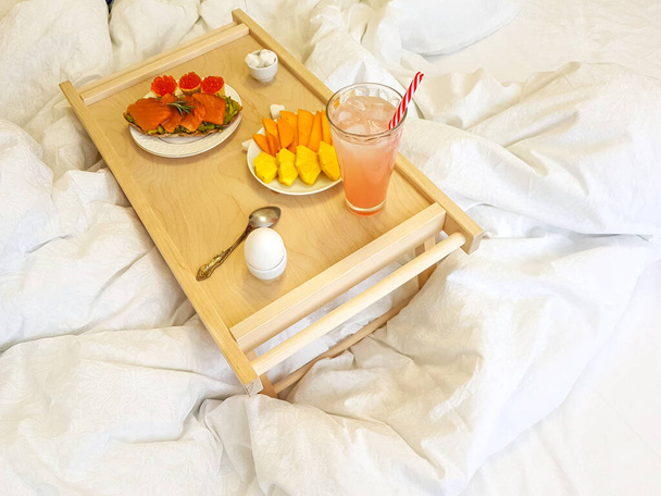 Healthy breakfast in bed for a girl in a cozy bedroom. - Фото, зображення