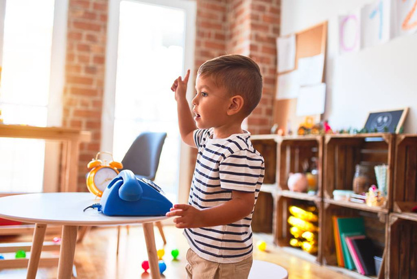 Schönes Kleinkind spielt im Kindergarten mit blauem Telefon - Foto, Bild