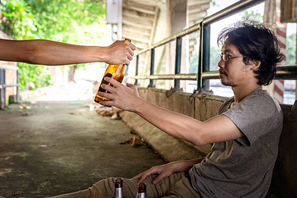 Portrait hand handed liquor to a drunken man and he took it. - Фото, изображение