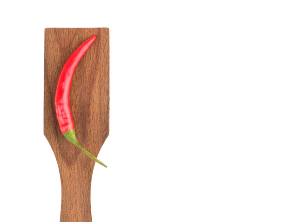 Red chili pods on wooden spatula white isolated background. Indi - 写真・画像