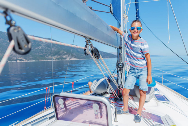 Little boy on board of sailing yacht on summer cruise. Travel adventure, yachting with child on family vacation. - Foto, Bild