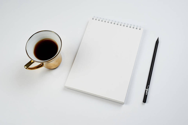 white office Desk top view with Notepad, pencil and coffee Cup, minimalistic design, top view,copy space,flat lay - Zdjęcie, obraz