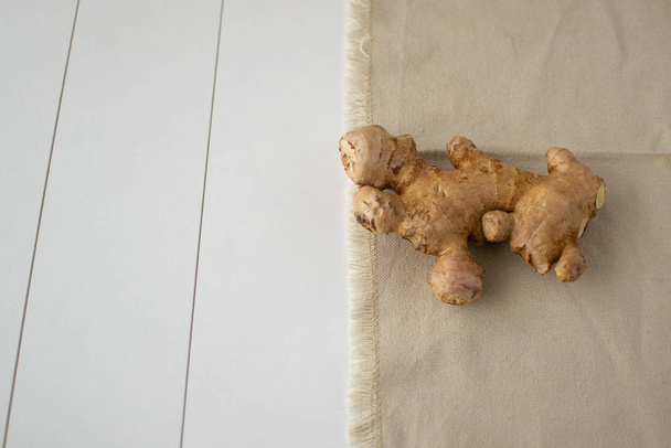 Fresh ginger root on a light background. Ginger is suitable for cooking and preparing drinks. Close-up - Fotografie, Obrázek