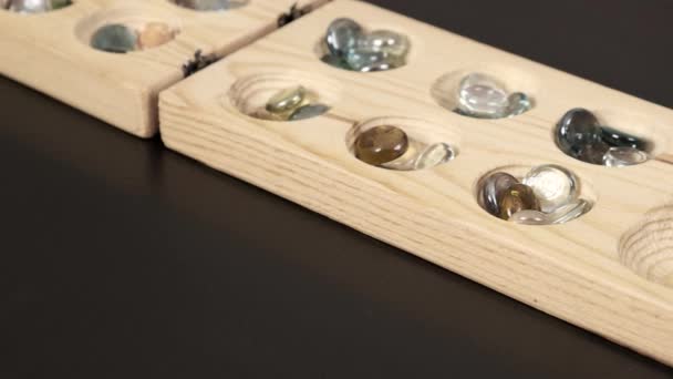 juego de mangala de madera, tablero de juego de mangala y canicas de vidrio
 - Metraje, vídeo