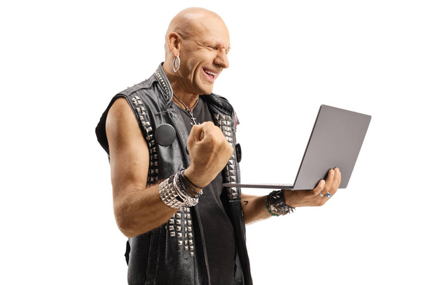 Hombre calvo en un chaleco de cuero gesticulando sí y sosteniendo una computadora portátil c
 - Foto, imagen