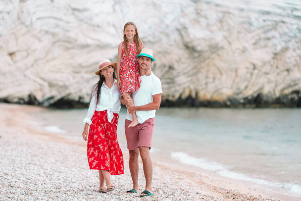 Молодая семья на белом пляже во время летних каникул - Фото, изображение