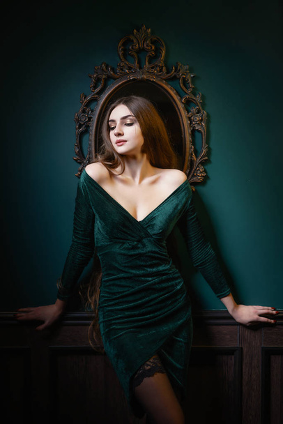 Beautiful woman with long hair sensual greed dress and stockings studio photoshoot - Fotografie, Obrázek