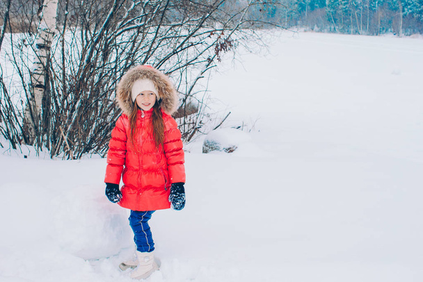 Porträt eines kleinen entzückenden Mädchens im Schnee sonnigen Wintertag - Foto, Bild