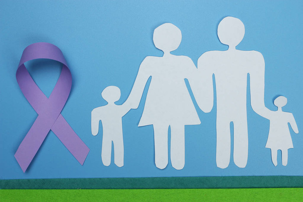 Сім'я вирізана з паперу і пурпурової стрічки для підвищення обізнаності про хворобу Альцгеймера.. - Фото, зображення