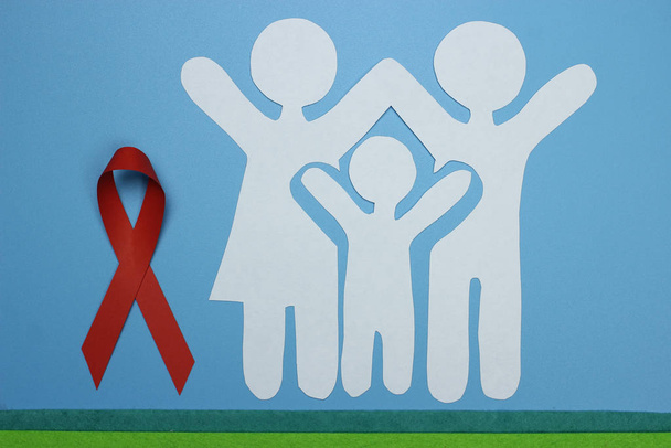 Red Ribbon and Paper silhouette of family. AIDS awareness symbol - Fotografie, Obrázek