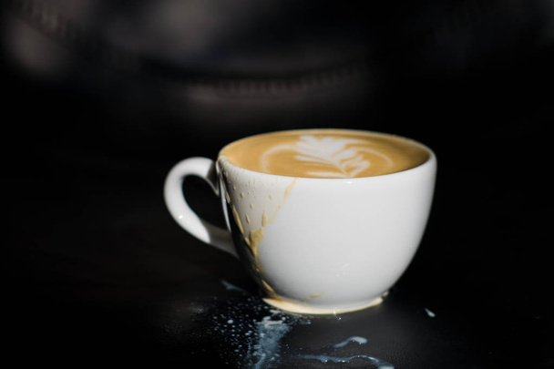 White ceramic a cup of cappuccino with picture spilled, latte art in coffee shop. The morning drink. - 写真・画像