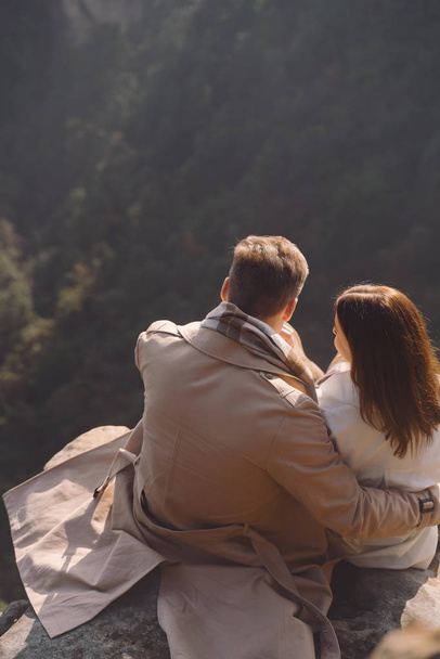 coppia appena invidiata che si abbraccia e si tiene per mano mentre sono seduti su una roccia al parco forestale nazionale zhangjiajie
 - Foto, immagini
