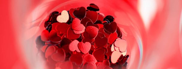 Kırmızı kalpler bir bardağa dağılmış. Sevgililer Günü konsepti. - Fotoğraf, Görsel