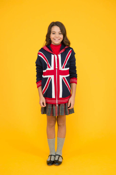 Culture and customs. Small girl school uniform. English student. Education and upbringing. Language school. English kid yellow background. Learn english language. British accent. Great Britain flag - Fotoğraf, Görsel