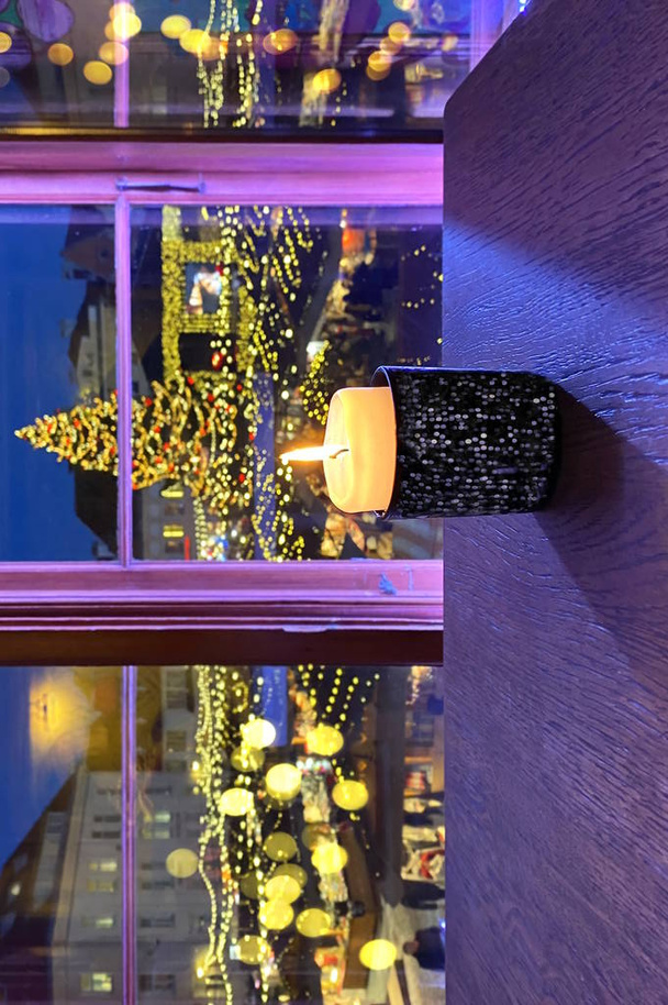  Різдвяна ялинка і різдвяна свічка на стільці, вікна Талліннський зимовий різдвяний відпочинок в Європі Новорічний міський ринок Світловий ринок Естонія від вікна ресторану Світло свічки - Фото, зображення