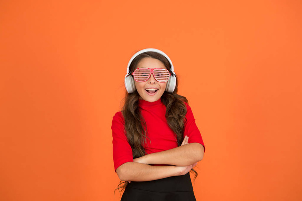 feeling stylish and confident. school radio dj. small happy girl listen music in headphones. funny child in party glasses. time for having fun. modern kid enjoy music. looking smart and funny - Photo, image