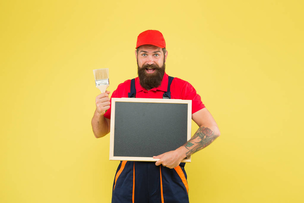 Advertisement concept. bearded worker painting brush. brutal builder man start own business. announcement and advertisement. copy space. professional repairer wanted. builder man paint on blackboard - Foto, immagini