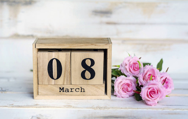 march 8 wooden calendar cubes with pink roses on white table - Photo, image