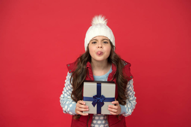 Meanie grimace. Christmas gifts. Receiving surprise present concept. Gift for female. Send parcel. Delivery service. Xmas gift idea. Winter holidays. Kid girl winter outfit hold wrapped gift box - Photo, image