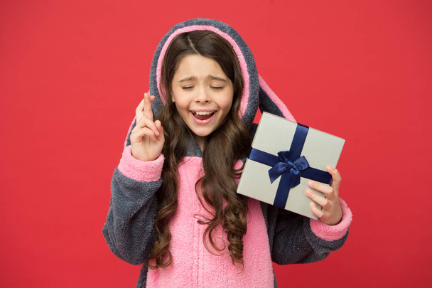 Hope for the best. Girl in bunny pajamas. Child in rabbit kigurumi. Happy girl in cute pajamas. Lifestyle concept. Rest and relax. Child in pajamas hold wrapped gift box. Shop and shopping concept - Foto, imagen