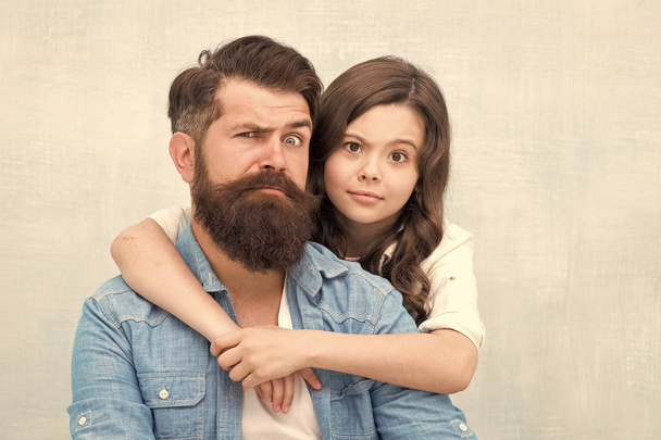My father is the best. Small girl child hugging father on grey background. Bearded father and little daughter grimacing and having fun together. My father is my friend. - Foto, Bild