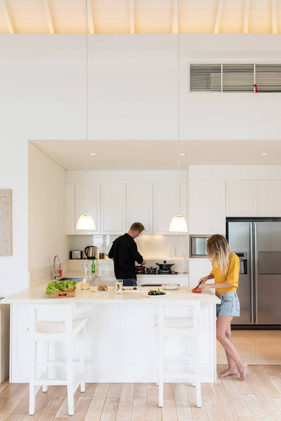 Пара делает салат на белом острове кухня дома
 - Фото, изображение