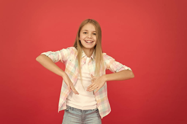 hip and stylish. smiling blonde kid. child girl with long blonde hair. casual style. childrens day. fashionable little girl. kid fashion. stylish beauty. small girl red background. happy childhood - Valokuva, kuva