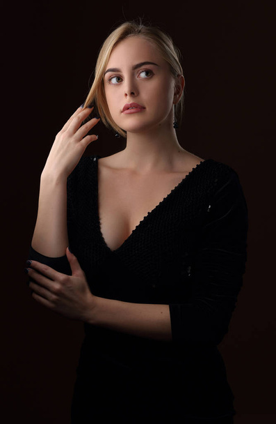 Blonde girl in a black dress with a deep neckline - Фото, зображення