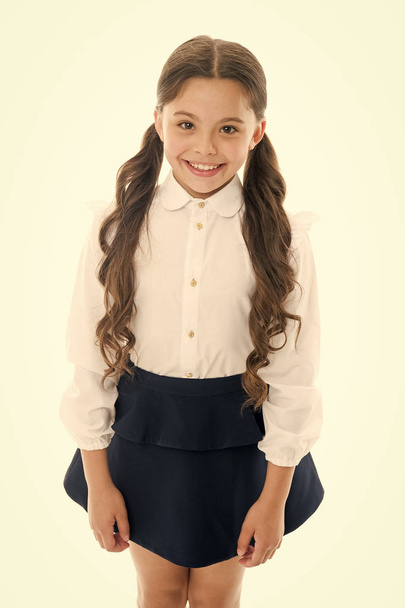 Back to school. Student little kid adores school. Pupil of first grade. Smiling schoolgirl. Celebrate knowledge day. September time to study. Girl cute pupil on white background. School uniform - Фото, изображение
