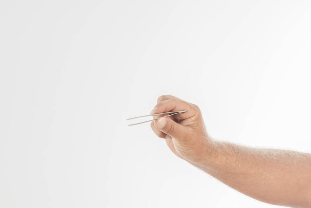 Close-up of a male hand holding tweezers - Foto, Imagem