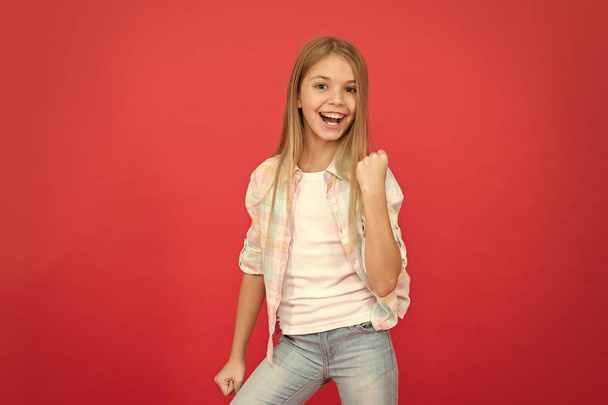 believe in better. small girl red background. happy childhood. smiling blonde kid. child girl with long blonde hair. casual style. childrens day. fashionable little girl. kid fashion. stylish beauty - Foto, imagen