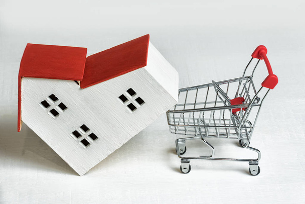 Modell von Haus und Korb auf weißem Hintergrund. Hauskauf. Immobilien- und Hypothekenkonzept. - Foto, Bild