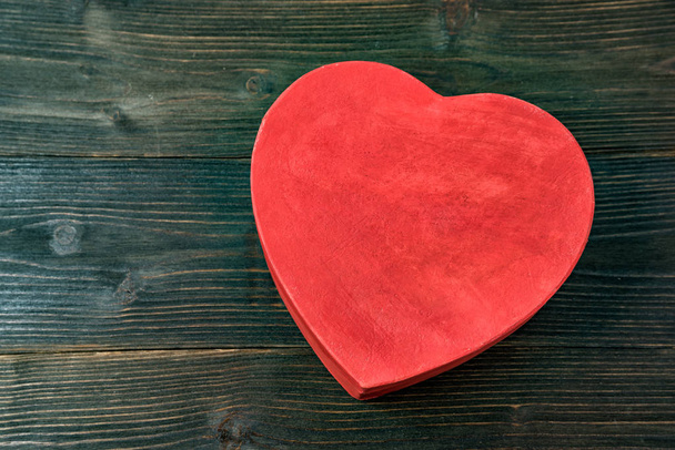 Vintage stijl rode hartvormige doos op de bruine houten tafel. Bovenaanzicht. Cadeau voor Valentijnsdag. Close-up - Foto, afbeelding