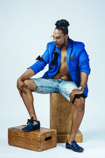 Studio portrait of a man with blue outfit and blue lips. Meditative - Photo, image