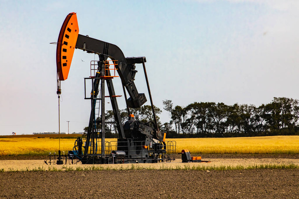 Pompage de puits de pétrole dans le paysage rural
 - Photo, image