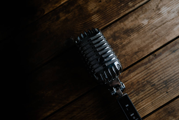 Retro microphone on dark wooden background - Foto, afbeelding
