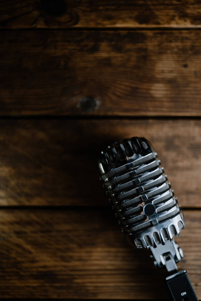 Retro microphone on dark wooden background - Photo, image