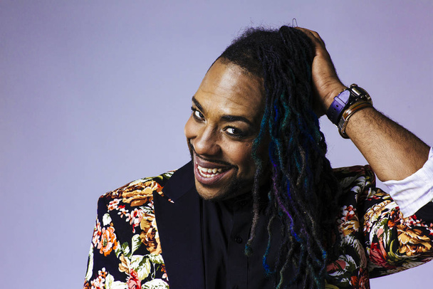 Studio portrait of a man wearing a flower patterned suit and dreadlocks - Photo, Image