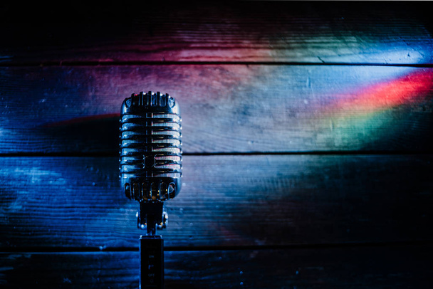 Retro microfoon op houten achtergrond en verlichting - Foto, afbeelding