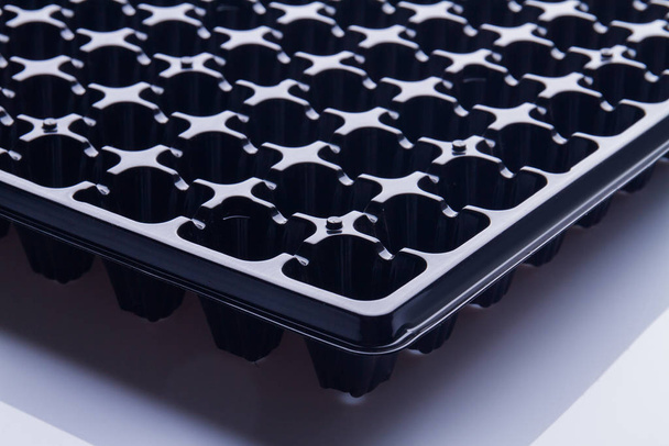 Extreme close-up black seeding tray cells. - Photo, Image