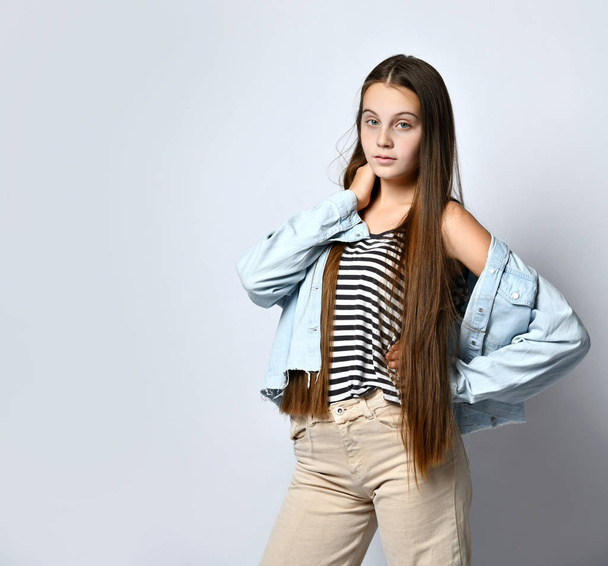 Teen lady in striped t-shirt, jeans jacket and pants. She looking at you, posing isolated on white studio background. Close up - Valokuva, kuva
