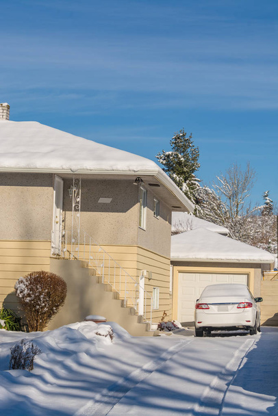 Schneebedeckte Wohnzufahrt mit weißem Auto - Foto, Bild