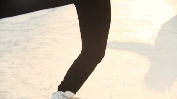 Młoda piękna blondynka zawodowa łyżwiarka figurowa na lodowisku kręcąca się wokół siebie - oświetlenie zachodu słońca - Materiał filmowy, wideo