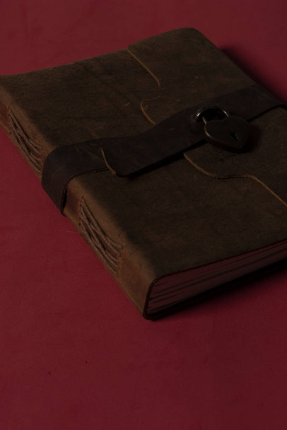 Cuaderno Antiguo para hacer un diario con todos los pensamientos de gratitud del dia en fondo rojo. Con llave en candado en forma de corazn, hojas tejidas.  - Photo, Image