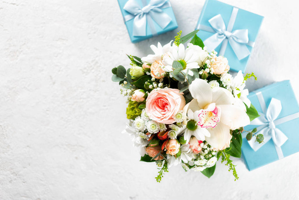 Flower bouquet with gift boxes on white background Flat lay, top view floral Valentine's Day or Mother's Day concept Copy space - 写真・画像