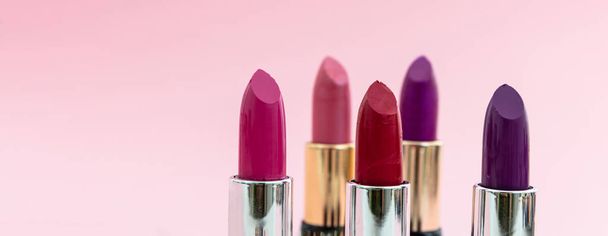 Lipsticks verschillende kleuren tegen roze achtergrond, close-up bekijken - Foto, afbeelding