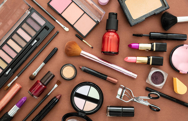 Make up cosmetici prodotti contro sfondo colore marrone
 - Foto, immagini