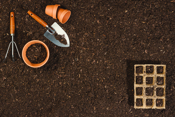 Gardening tools on soil texture background top view. - Foto, Imagen