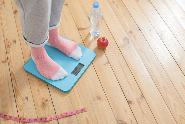 young woman on electronic scales on  wooden floor - Foto, Imagem
