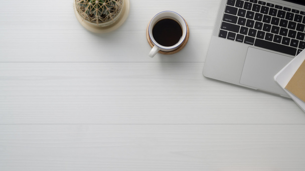 Снимок рабочего пространства с копировальным пространством, ноутбуком, чашкой кофе и кактусом на доске
  - Фото, изображение